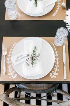 the place setting is set with white plates, silverware and napkins that are wrapped in twine