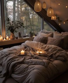 an unmade bed with candles on it in front of a window and some windowsills