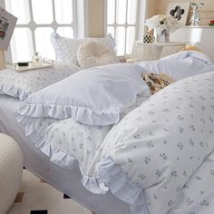 a bed with white sheets and pillows on top of it