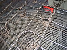 a pair of scissors sitting on top of a metal grate covered in wire mesh