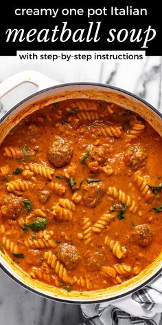 a large pot filled with pasta and meatballs in tomato sauce on top of a marble counter