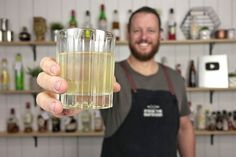 a man holding up a glass filled with liquid