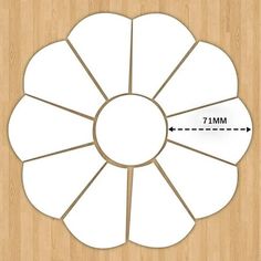 a white flower cut out on top of a wooden floor with an arrow pointing to the center