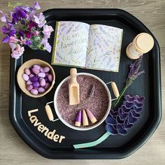 a tray that has some kind of crafting supplies on it, including flowers and an open book