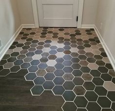 a bathroom floor with hexagonal tiles on the floor and door in the background