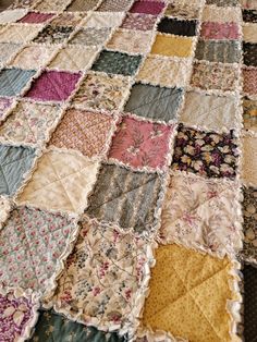 an old quilt that has been made into a tablecloth with many different colors and patterns