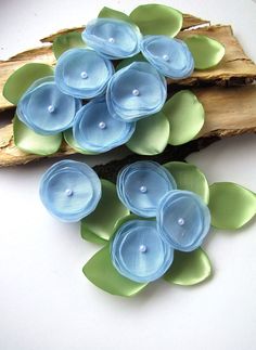 blue and green flowers are sitting on a piece of wood