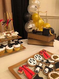 decorated cookies and cupcakes on a table