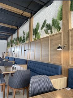 an empty restaurant with blue booths and wooden tables