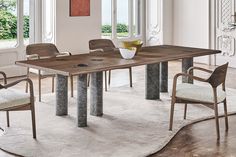 a dining room table with chairs and a rug on the floor in front of it