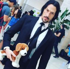 a man in a suit holding a stuffed dog