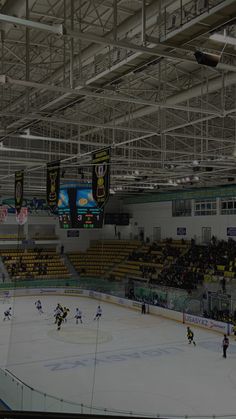 an indoor hockey rink with people playing on the ice