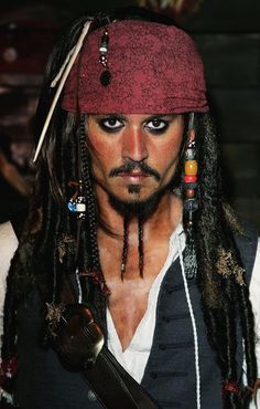 a man with long hair wearing a pirate costume