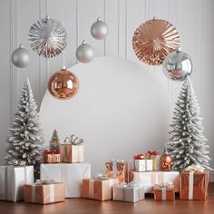 christmas decorations and presents on a wooden floor in front of a white wall with silver ornaments