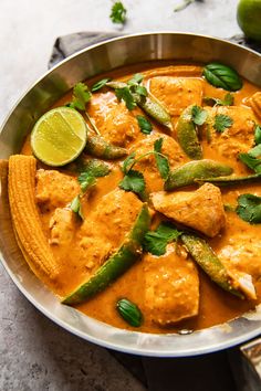 a pan filled with chicken and vegetables covered in sauce, garnished with cilantro