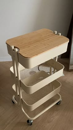 a kitchen cart with two trays on wheels and a cutting board attached to it