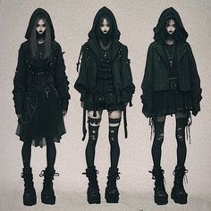 three women in black clothing standing next to each other with hoods and boots on