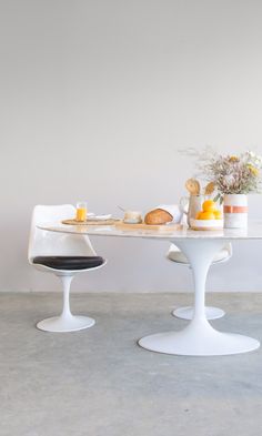 two white tulips sitting on top of a table