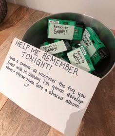 a bowl filled with lots of green batteries next to a sign that says help me remember tonight