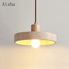 a white light hanging from a ceiling with a brown cord attached to it and the words atisha above it