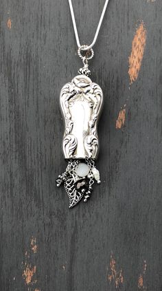 a silver necklace with an image of a woman's face on the front and side