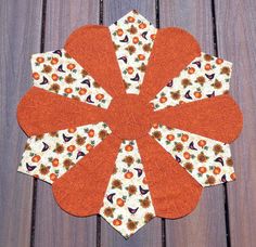 an orange and white flower on a wooden surface