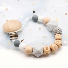 a wooden beaded bracelet with letters and stars around it on a white background,