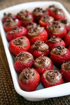 chocolate covered strawberries in a white dish on a table