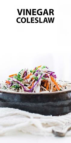 a bowl filled with coleslaw and carrots on top of a white table