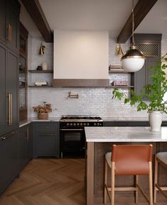 a kitchen with gray cabinets and white counter tops, wooden flooring and an island in the middle