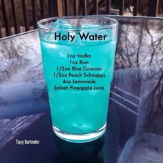 a glass filled with blue liquid sitting on top of a table