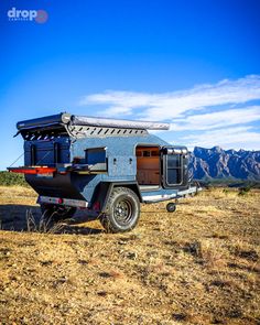 an off - road camper sits in the desert with mountains in the background