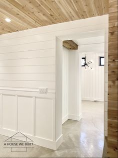 an empty room with white walls and wood paneling on the ceiling is seen in this image