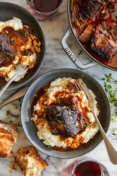 three pans filled with meat and mashed potatoes on top of a marble table