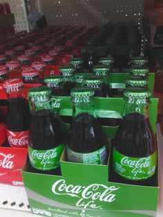 several bottles of coca - cola on display in a store