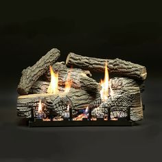 a close up of a fire place with logs on the top and flames in the middle