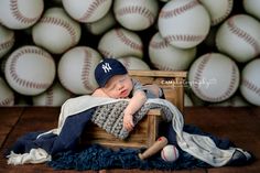 a baby sleeps in a crate with baseballs behind it