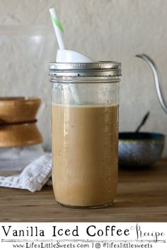 a mason jar with a straw in it on a table next to bowls and utensils