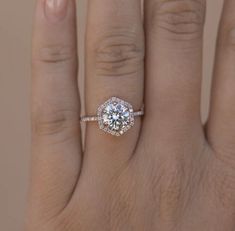 a woman's hand with a diamond ring on it, and the middle finger