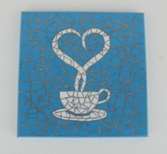 a blue mosaic tile with a coffee cup in the shape of a heart on it