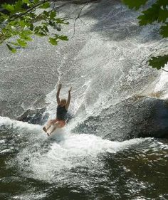 a person riding a surfboard on top of a wave in the water at a river