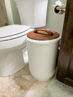 a white toilet sitting next to a trash can