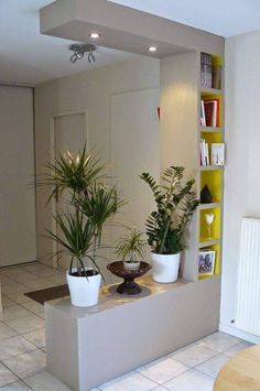 three potted plants are sitting on a ledge in the middle of a living room