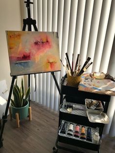 an easel with paint, brushes and other art supplies