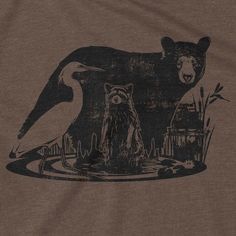 a brown shirt with an image of a bear and a bird on it