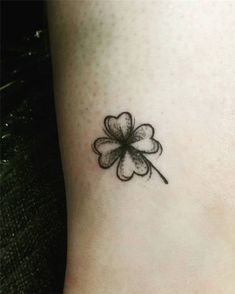 a small four leaf clover tattoo on the side of a woman's leg,