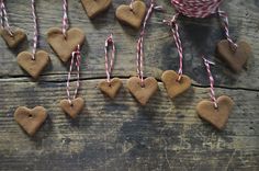 some heart shaped cookies hanging from twine with candy canes around them on a wooden table