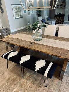 a dining room table with chairs and a bench in the middle of it on a hard wood floor