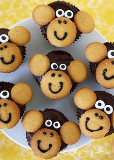 some cupcakes with eyes and noses on top of a white plate in the shape of monkeys