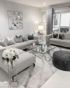 a living room filled with lots of furniture and white flowers on top of a table